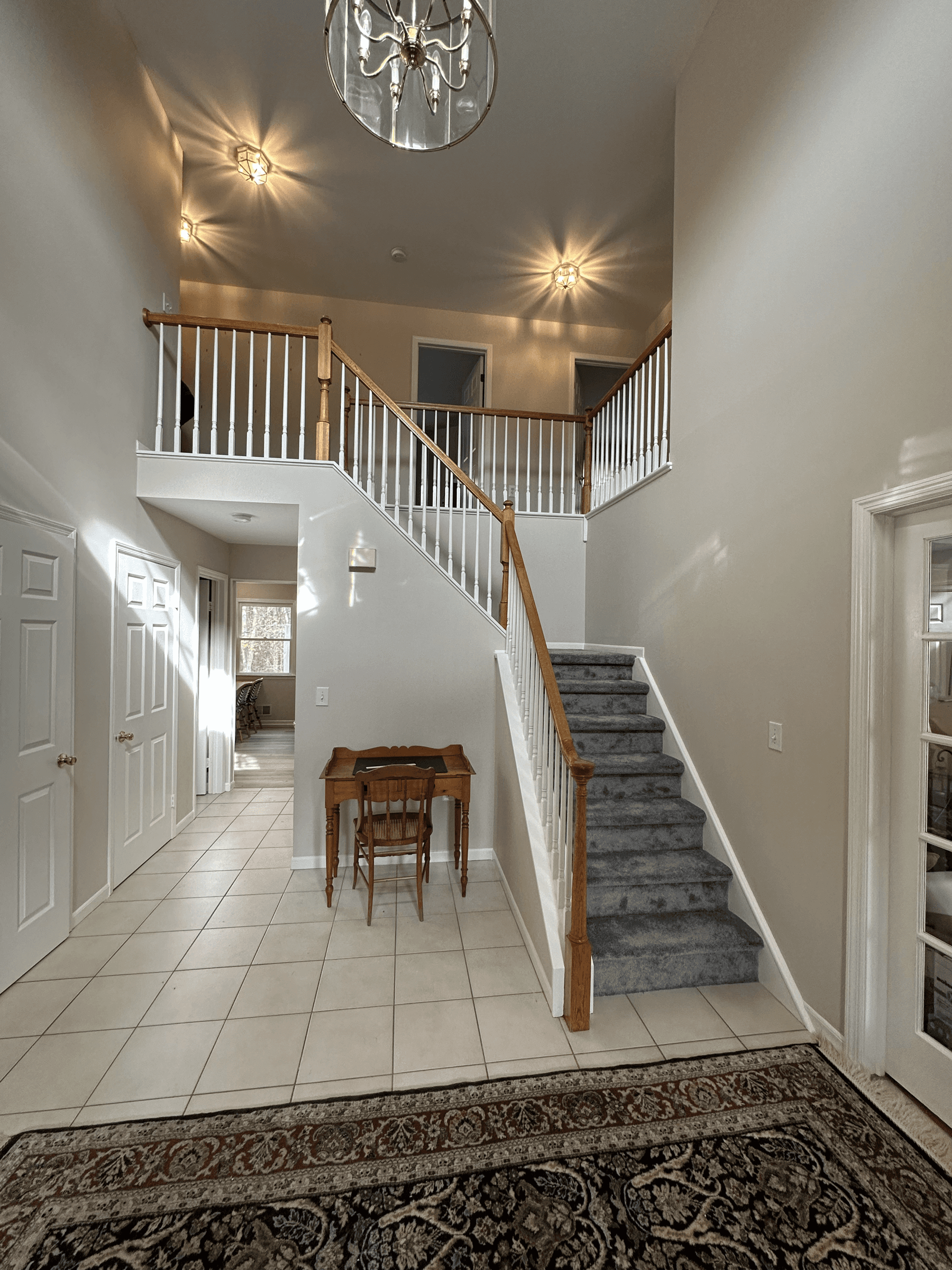The same foyer with light walls and white stair spindles, after painting