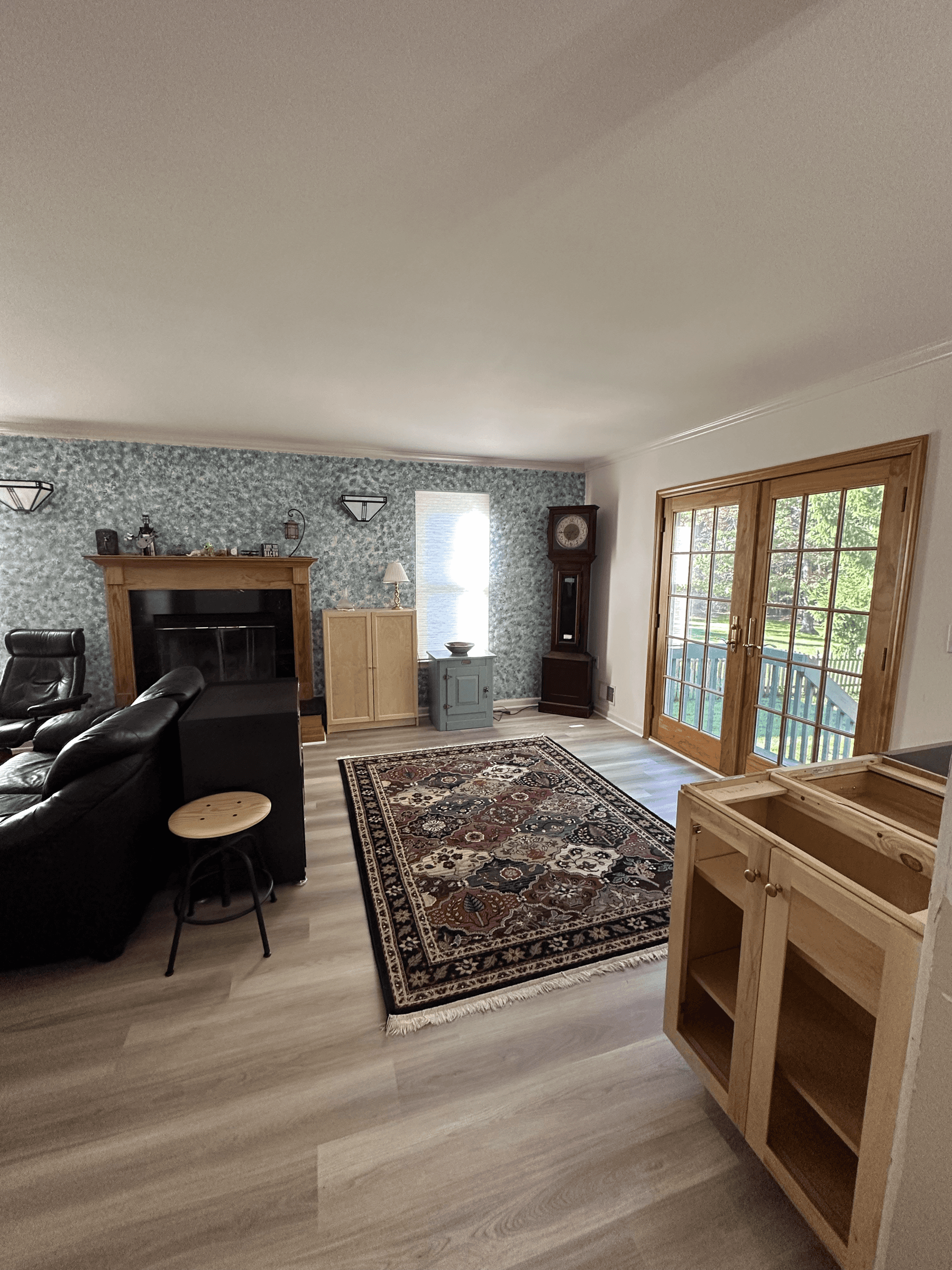 Living room with a patterned accent wall around the fireplace, before painting