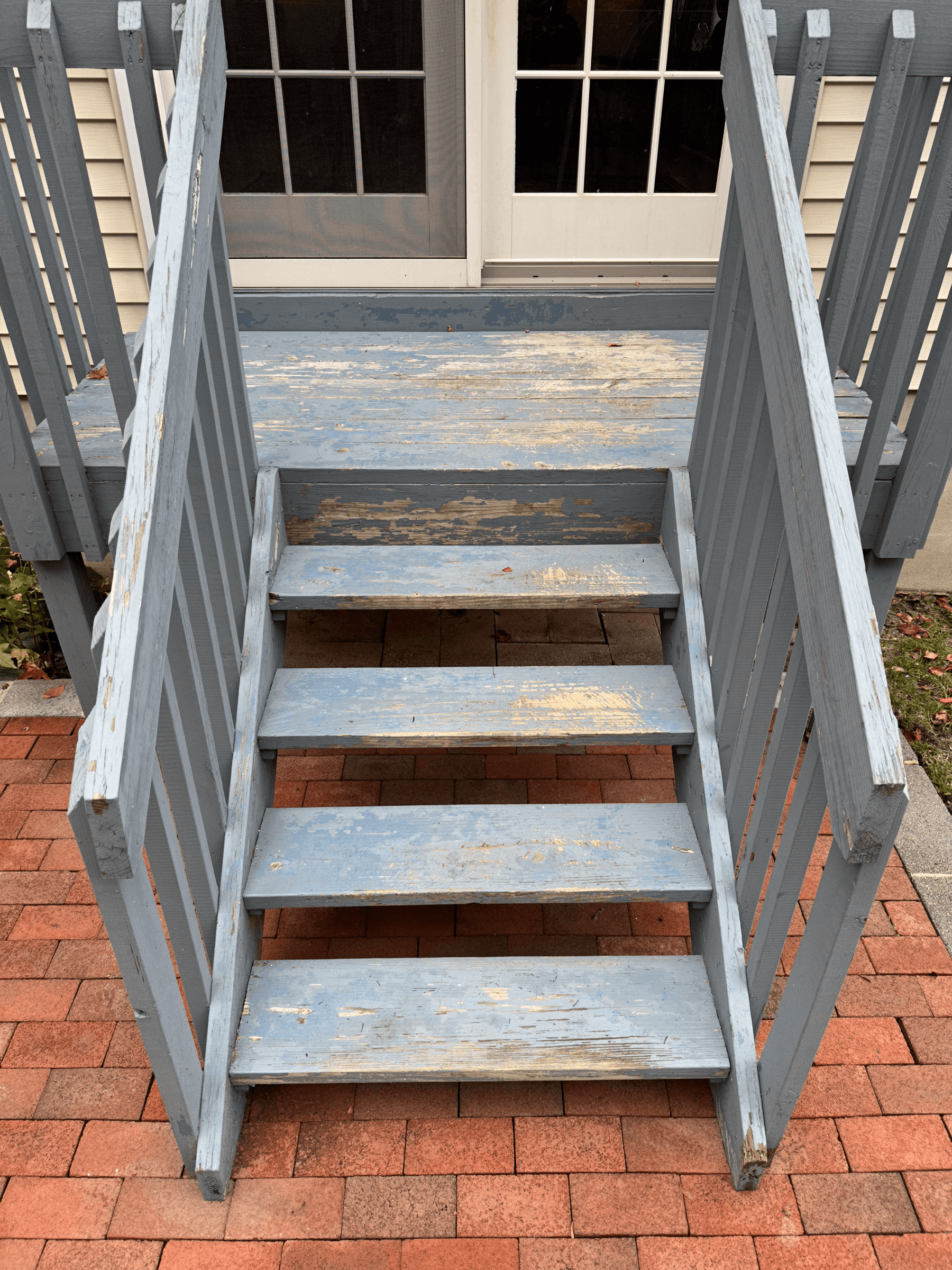 Back stairs with worn blue-gray paint peeling off the treads, before painting
