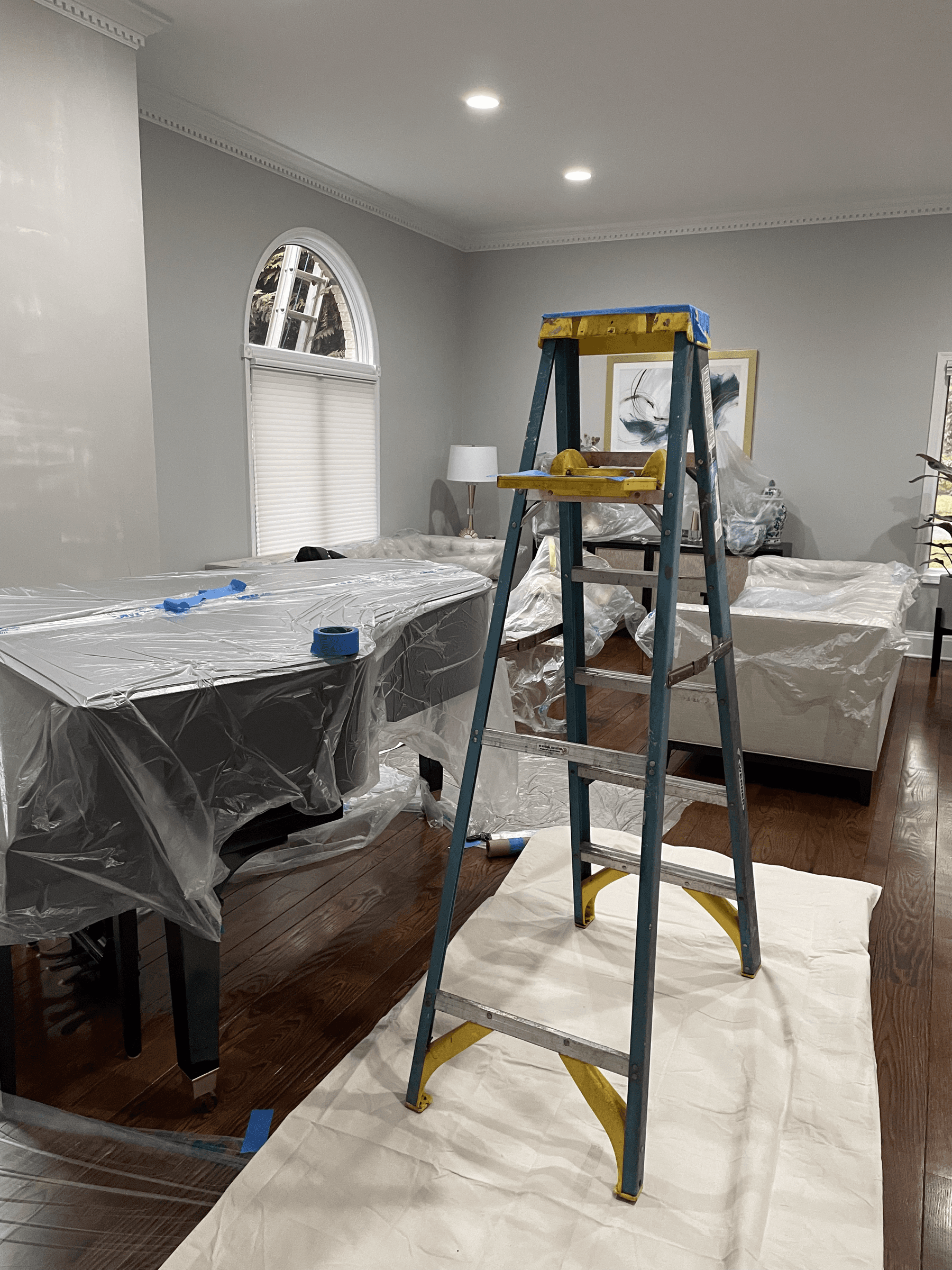 Furniture wrapped in plastic and the floor covered before painting
