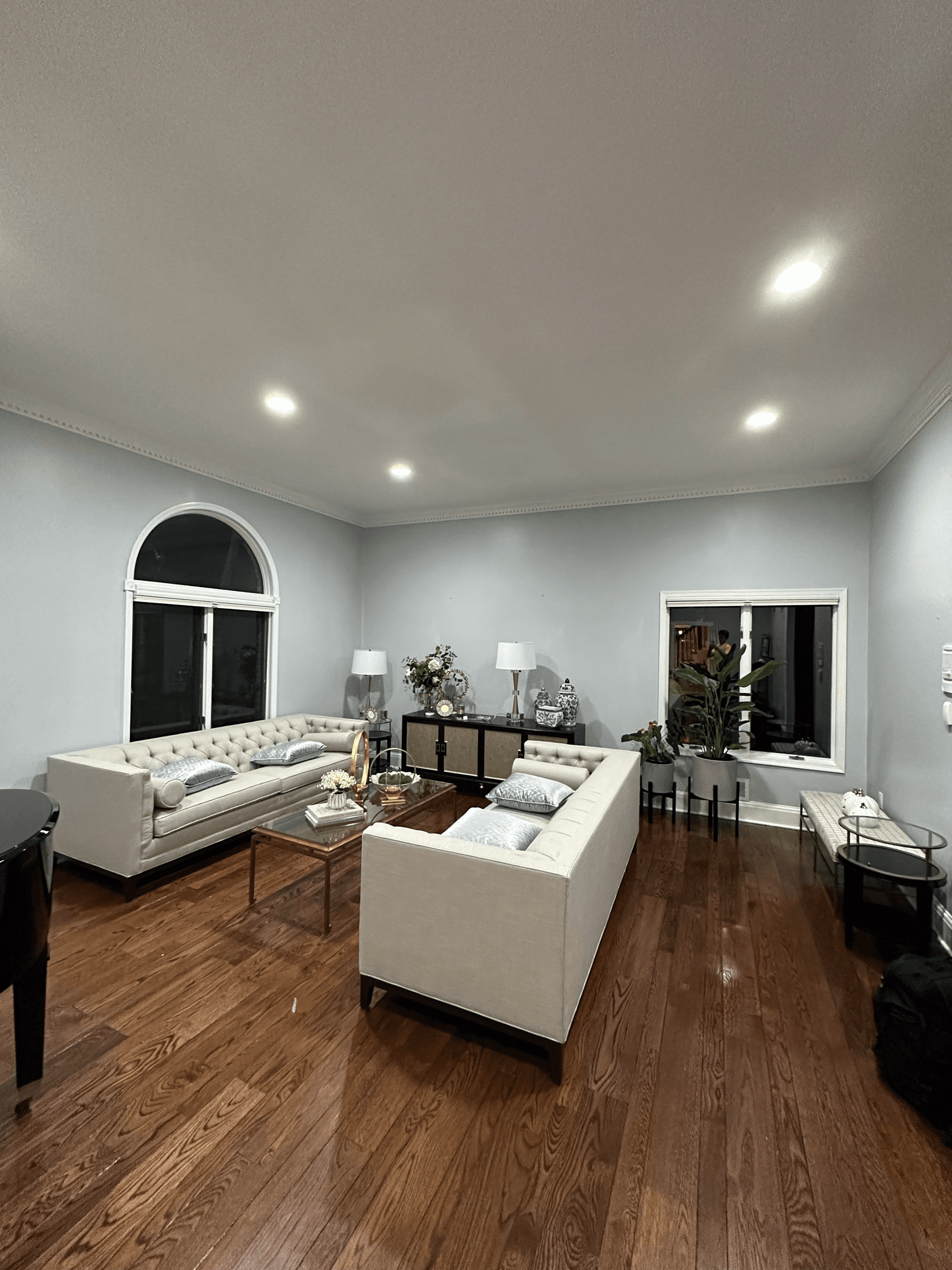 Living room with light gray walls, white trim and an arched window